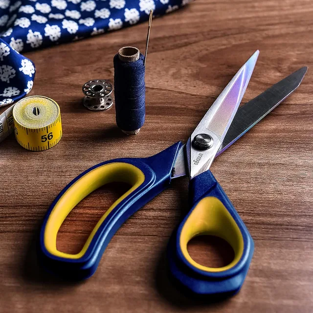 Navy and yellow LIVINGO titanium shears beside sewing thread and fabric